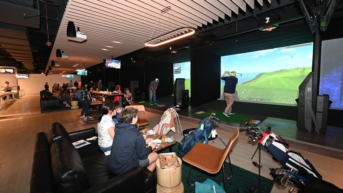 Golfzon Social in Palisades, New York, people play golf on a simulator in a bar